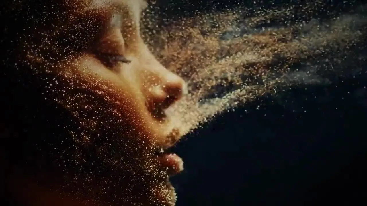 Rostro de una mujer de perfil entre partículas doradas